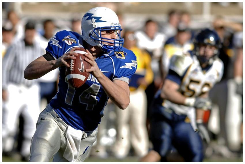 Player in blue jersey focuses on passing during a