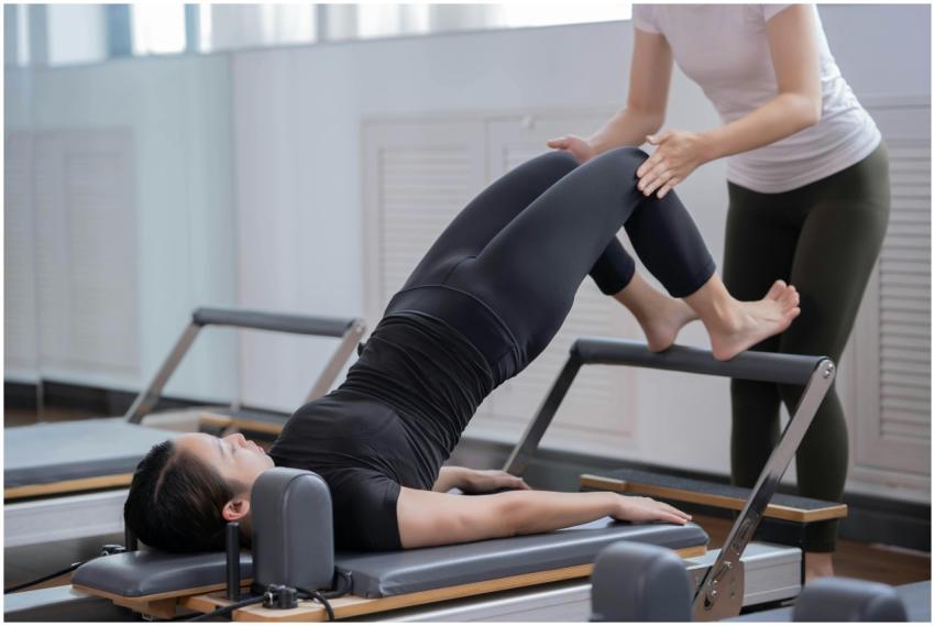 Women engaging in reformer Pilates with assistance