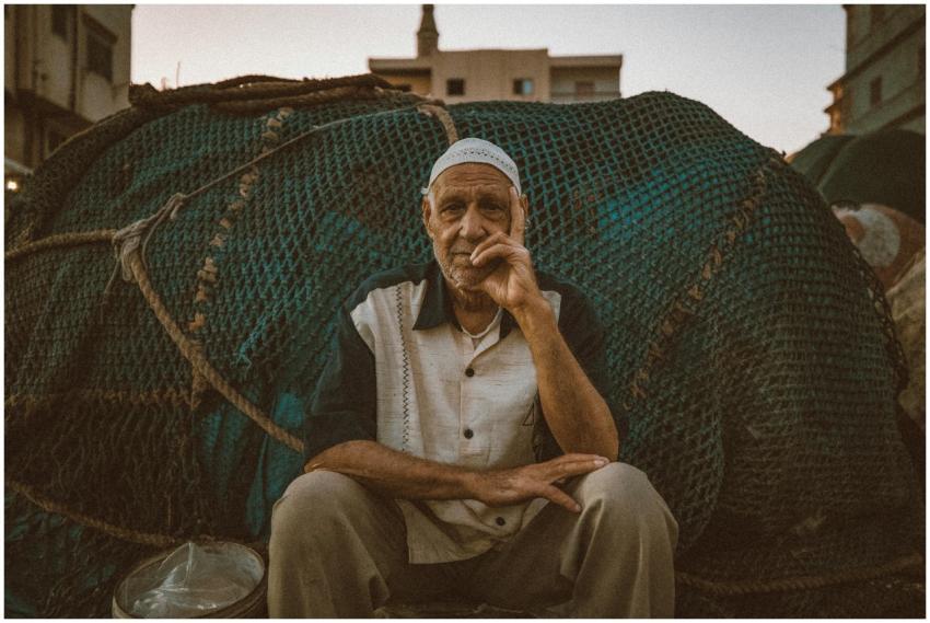 Candid portrait of a fisherman sitting in front of