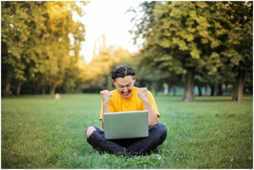 A young man in yellow celebrates success on his la