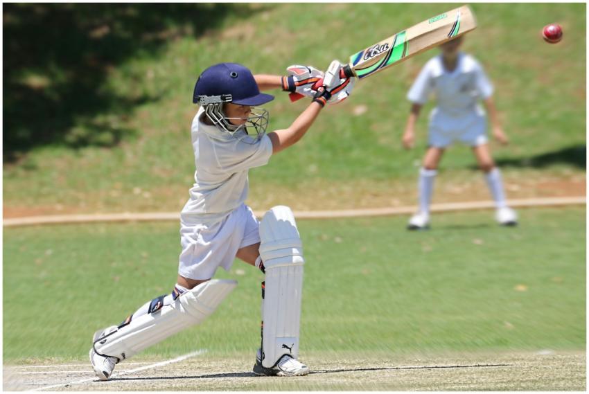 Young cricketer in white gear executing a sweep sh