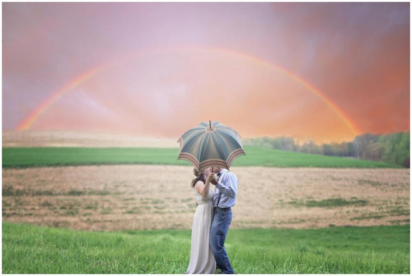 A couple shares a kiss under an umbrella in a scen