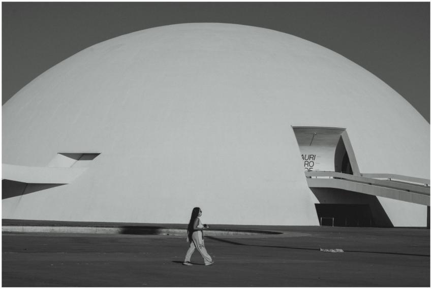 A woman walks by the futuristic Niemeyer Dome in B