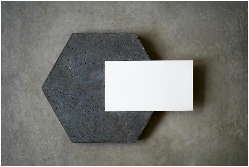 A blank white card placed on a textured concrete h