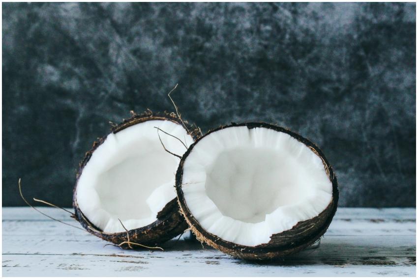 Halved coconut on rustic background, showcasing fr
