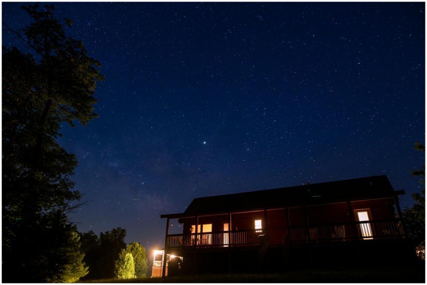 A serene view of a starry night sky over a rustic