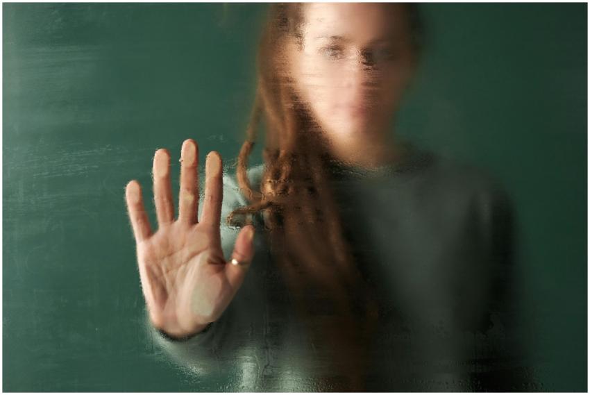 Blurred image of a woman with her hand pressed aga