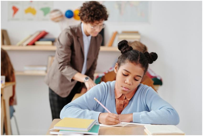 Focused young student writing during a classroom a