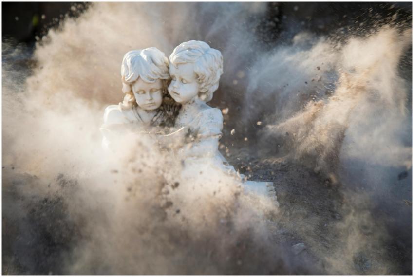Intricate stone statues engulfed in a dynamic dust