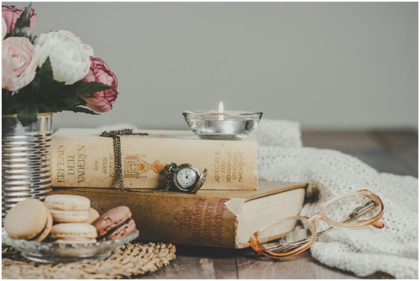 Vintage still life with books, macarons, candle, a