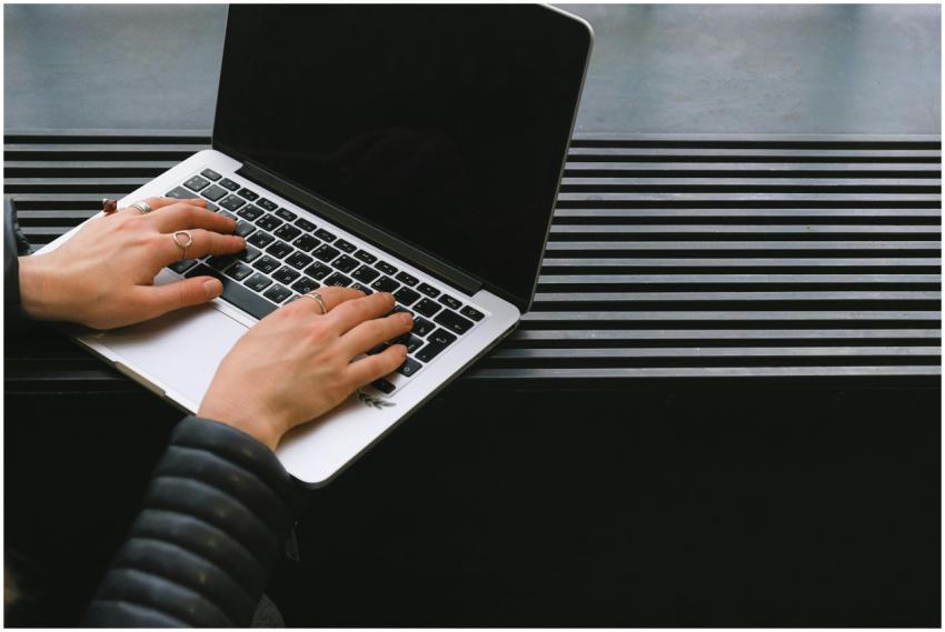Close-up of hands typing on a sleek laptop, ideal