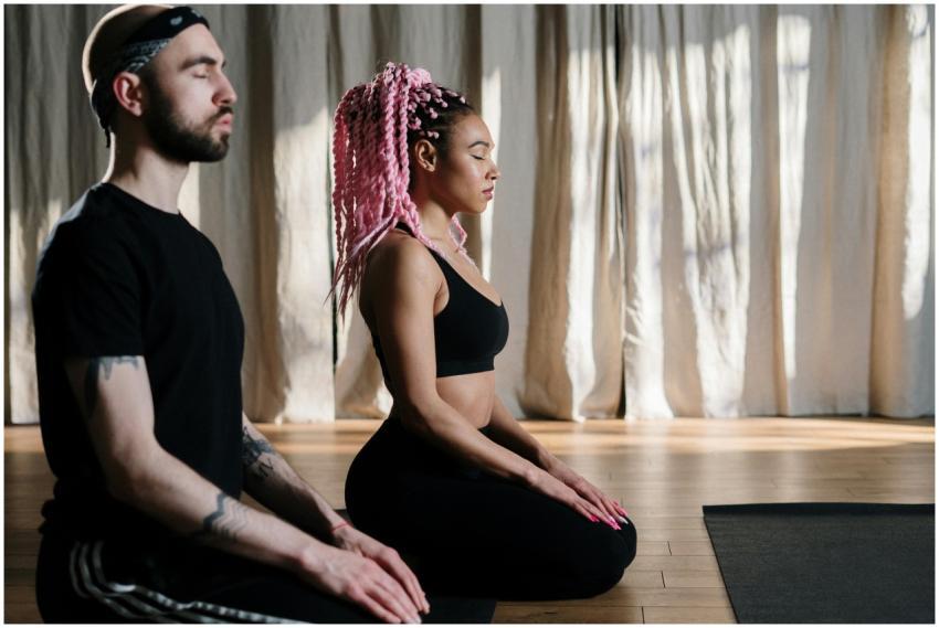 Two adults meditate in a serene yoga studio, embra