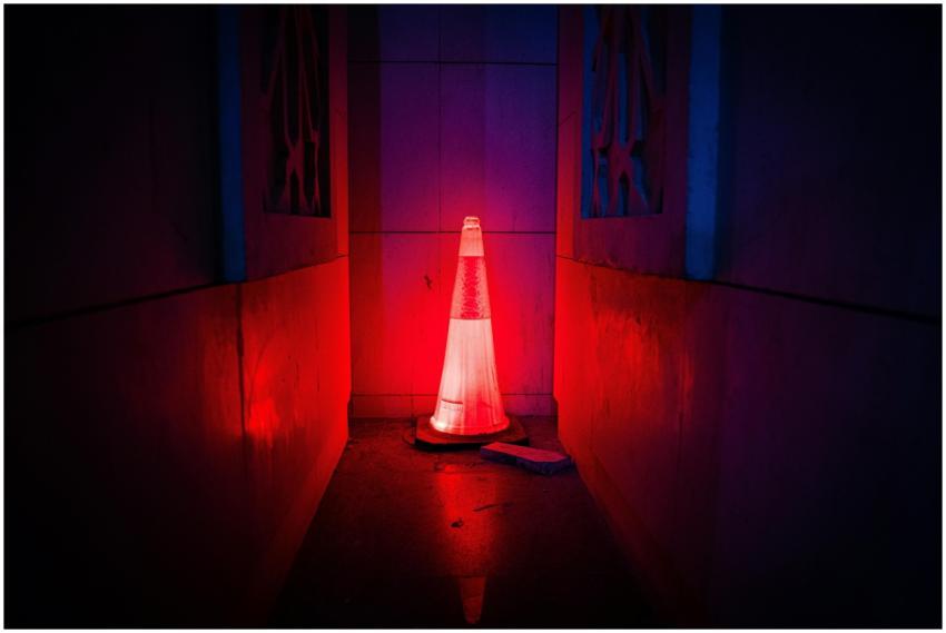 A red neon-lit traffic cone emits a mysterious glo