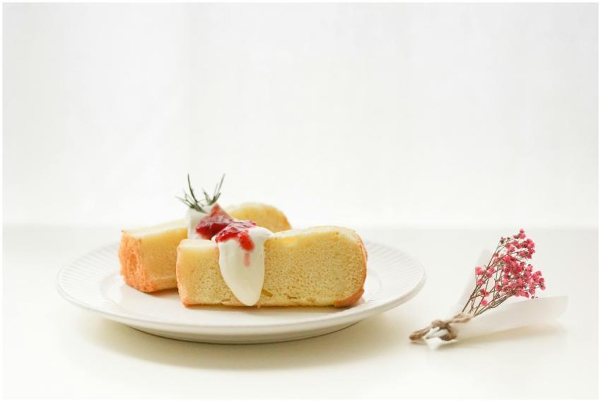 Slice of sponge cake with cream and berry topping