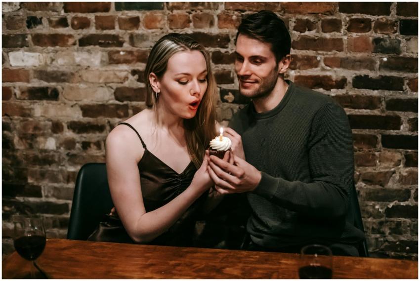 A couple shares a moment with a cupcake and candle