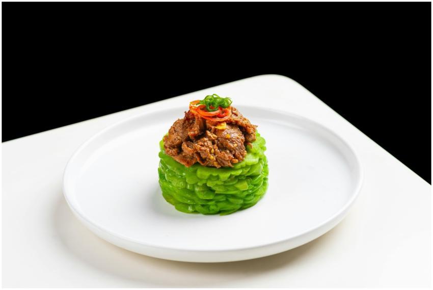 Elegant gourmet dish featuring beef atop melon, st