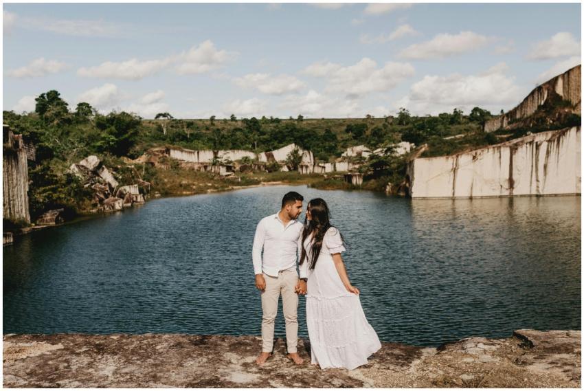 A young couple holding hands by a tranquil lake, s