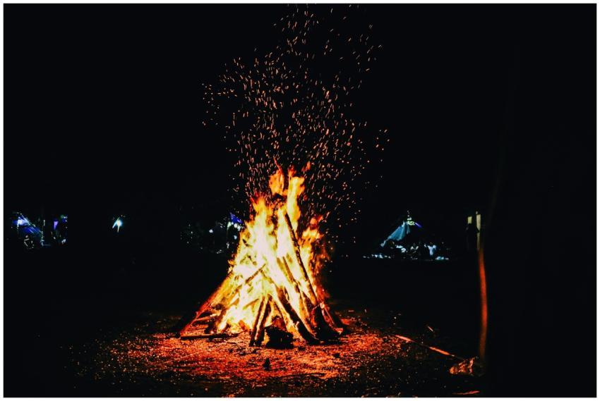A blazing campfire outdoors at night sparks warmth