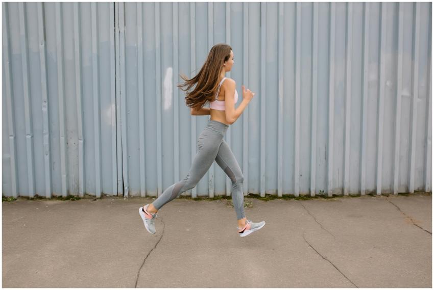 Fit woman running outdoors in activewear with spor