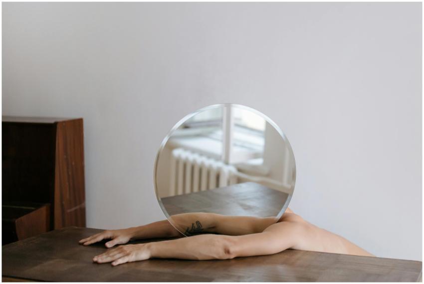 Artistic shot of arms holding a round mirror, refl