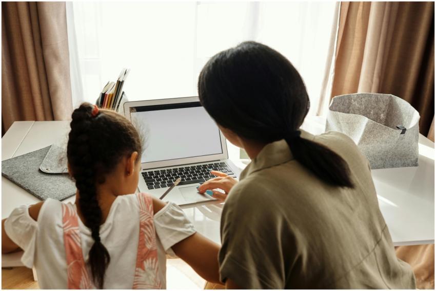 A mother helps her daughter with online learning o