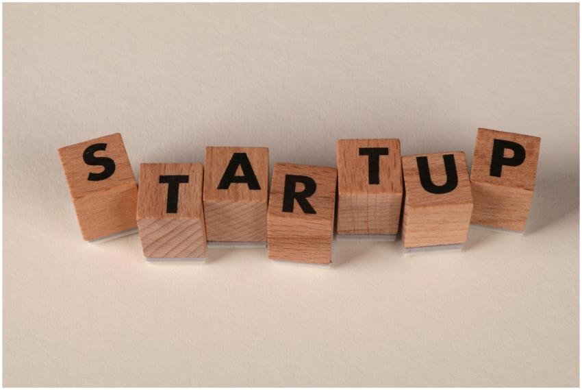 Wooden blocks forming the word 'STARTUP' on a neut