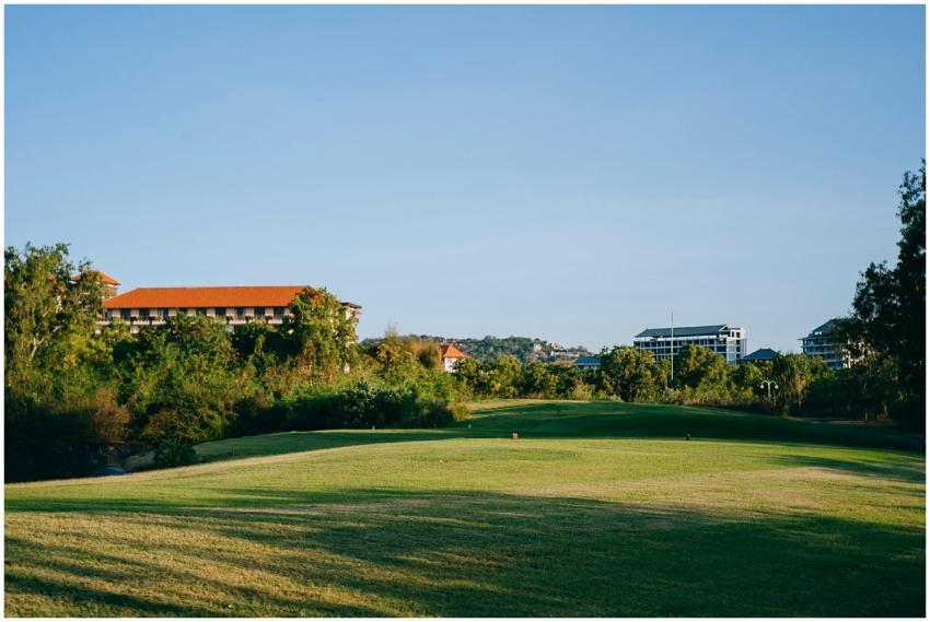 Scenic view of a golf course surrounded by greener
