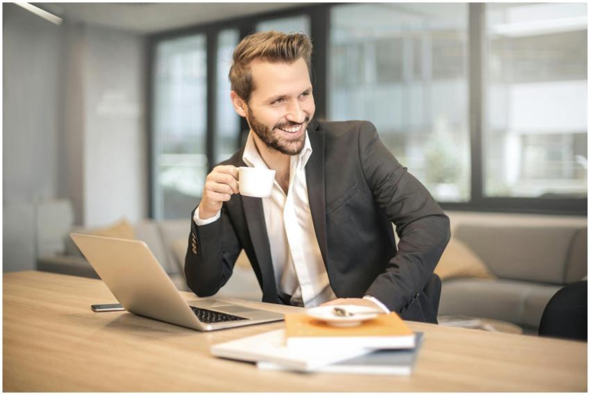 Smiling businessman in formal attire enjoying coff
