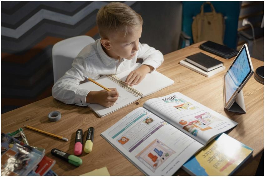 A focused young boy engages in distance learning w