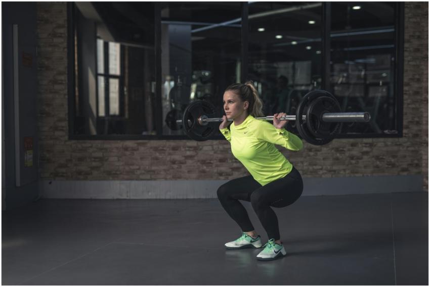 Dedicated woman in neon activewear performs a weig
