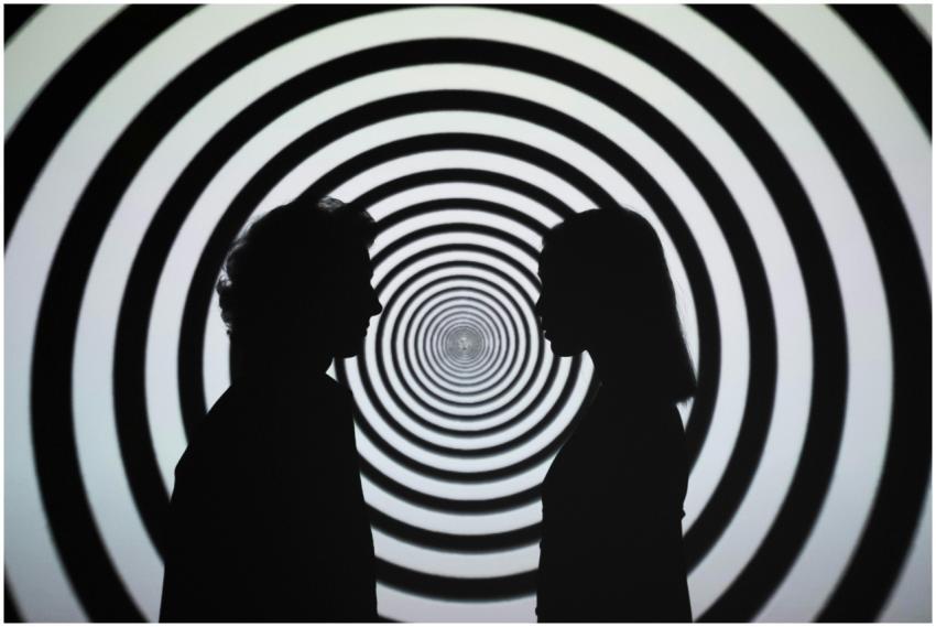 Silhouette of people facing each other with a hypn