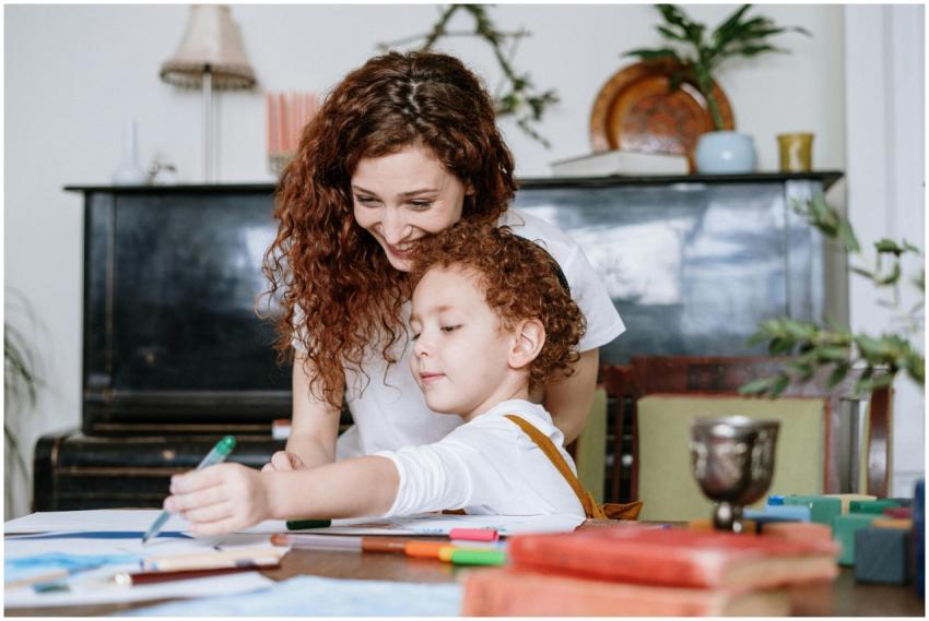 A loving mother and her child enjoy drawing togeth