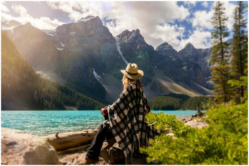 Woman in a poncho gazing at Moraine Lake surrounde