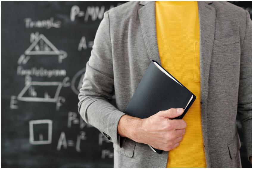 Close-up of a teacher with a notebook standing in