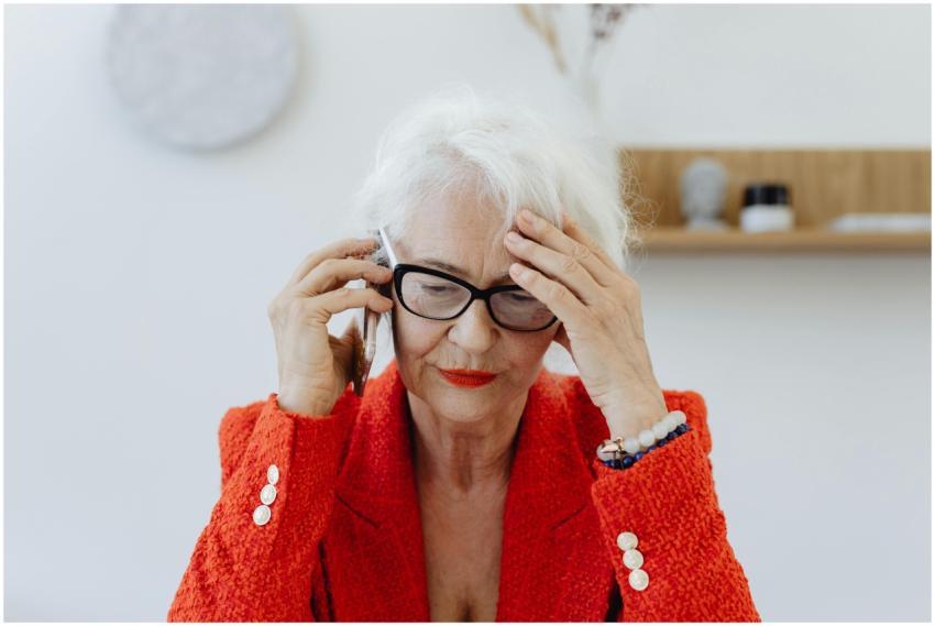 Senior woman in red blazer stressed while talking
