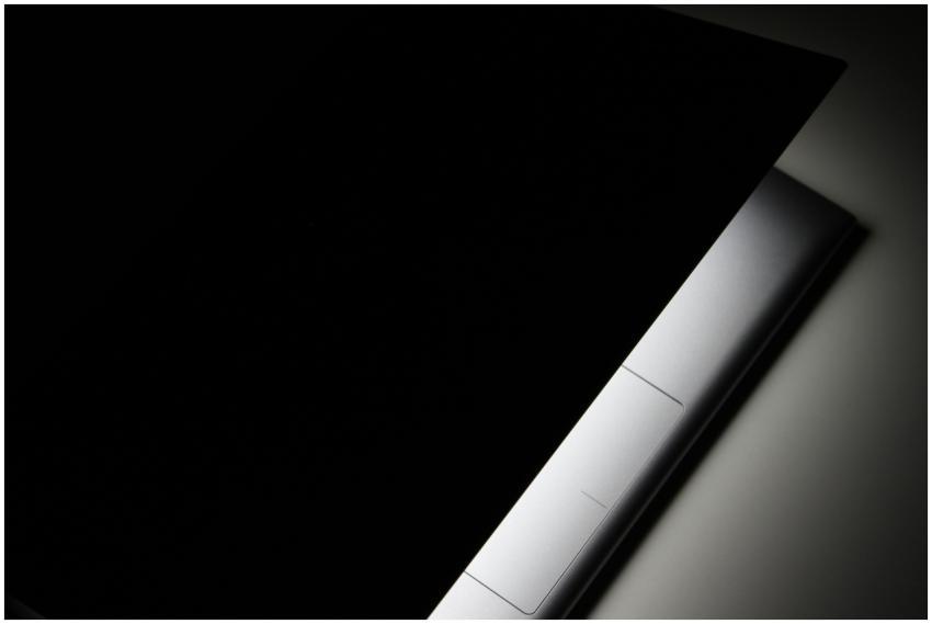 A partial view of a modern laptop closed in shadow