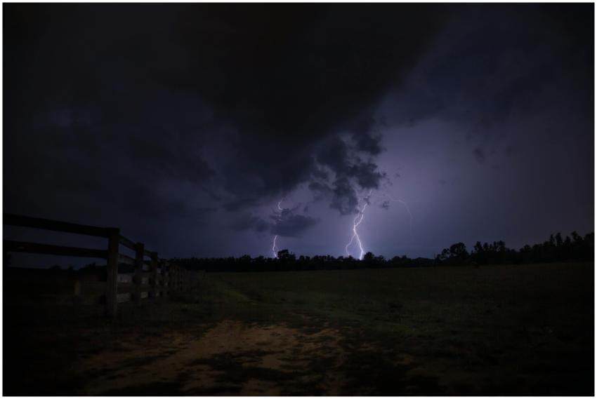 Intense lightning illuminates a dark field, captur