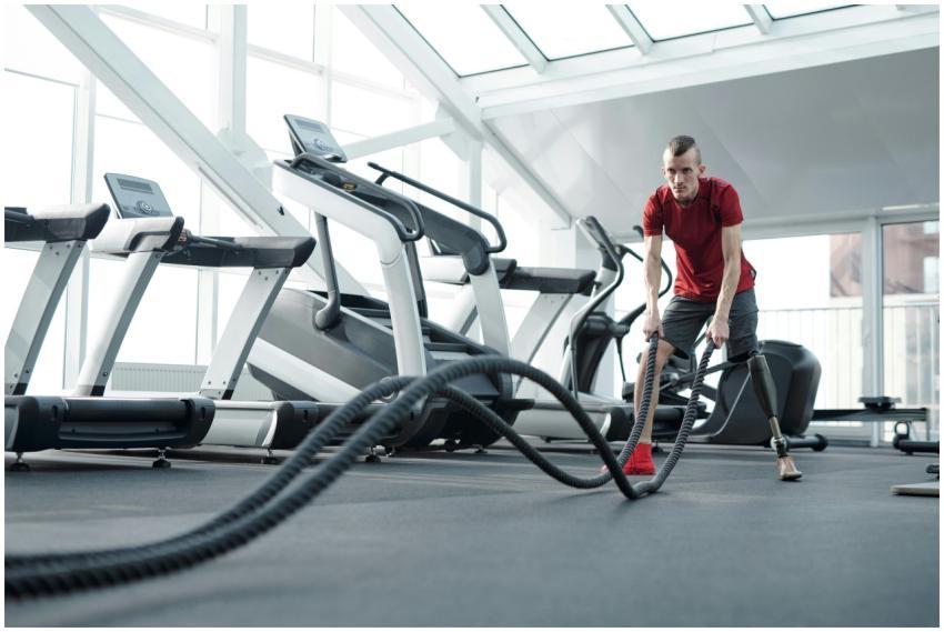 Young man with prosthetic leg working out in a mod