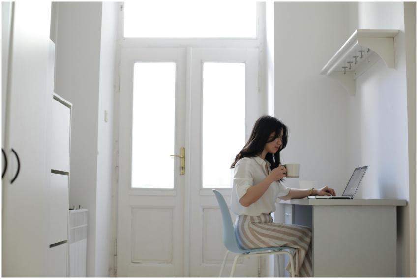 Asian woman working remotely on a laptop at a home