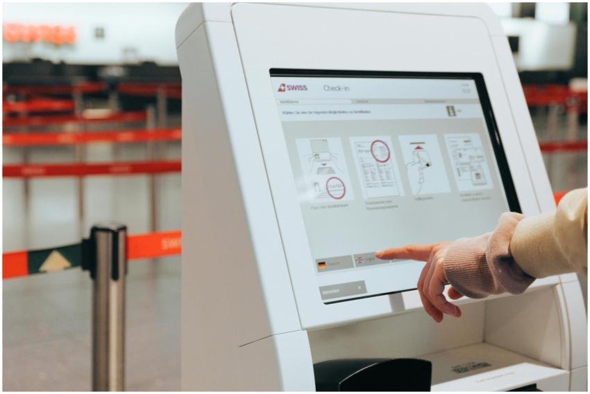 Passenger using self-service check-in kiosk at air