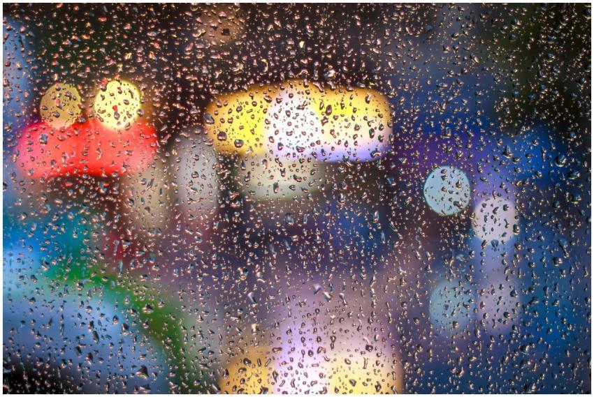 Raindrops on a window with vibrant city lights bok