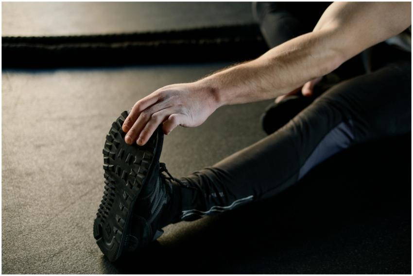 Close-up of a man's hand reaching for his foot whi