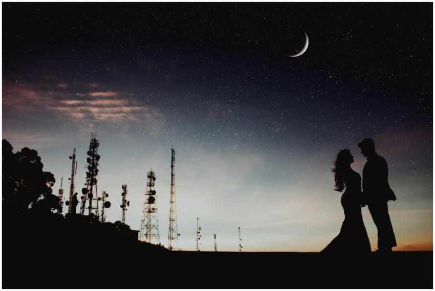 A couple's silhouette against a starry sky with a