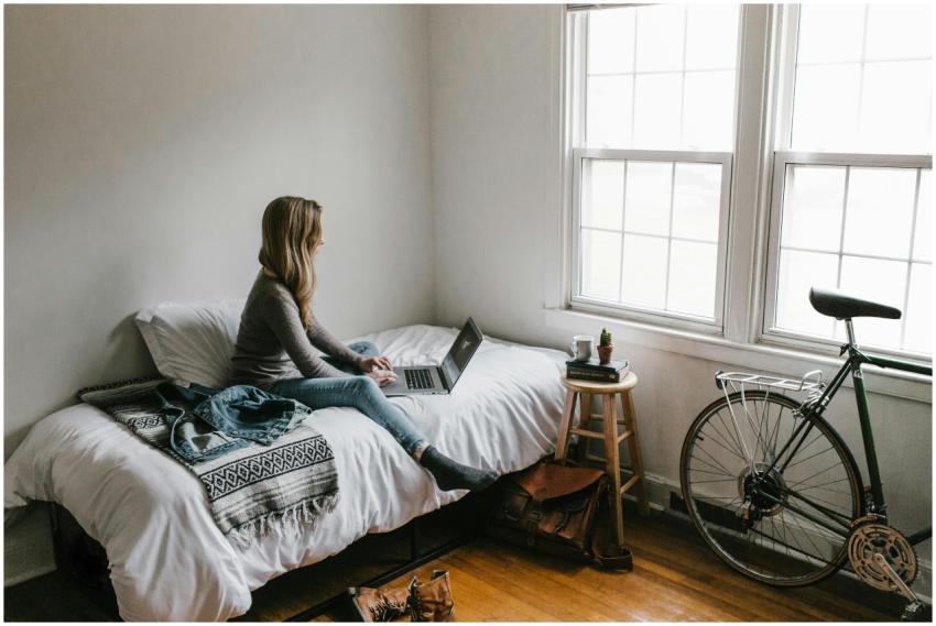 A young woman works on a laptop in a cozy, minimal