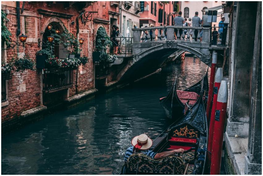 A scenic view of a gondola passing under a traditi