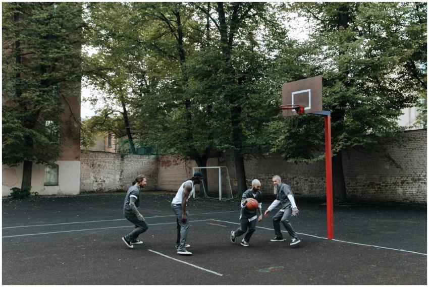Inmates play a basketball game on an outdoor priso
