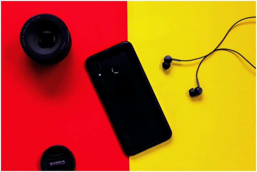 Colorful flat lay featuring a smartphone, camera l