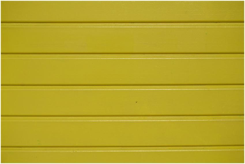 Close-up of a vibrant yellow wooden wall with text