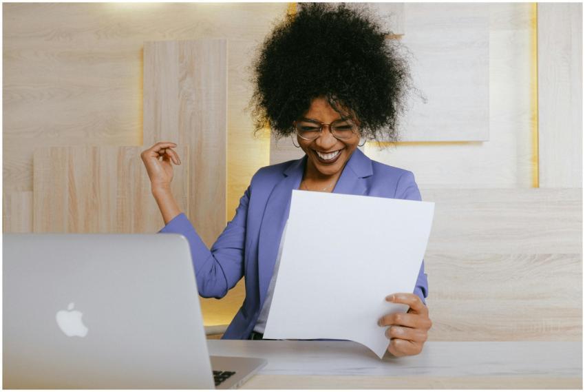 A cheerful woman celebrates her success at work, l