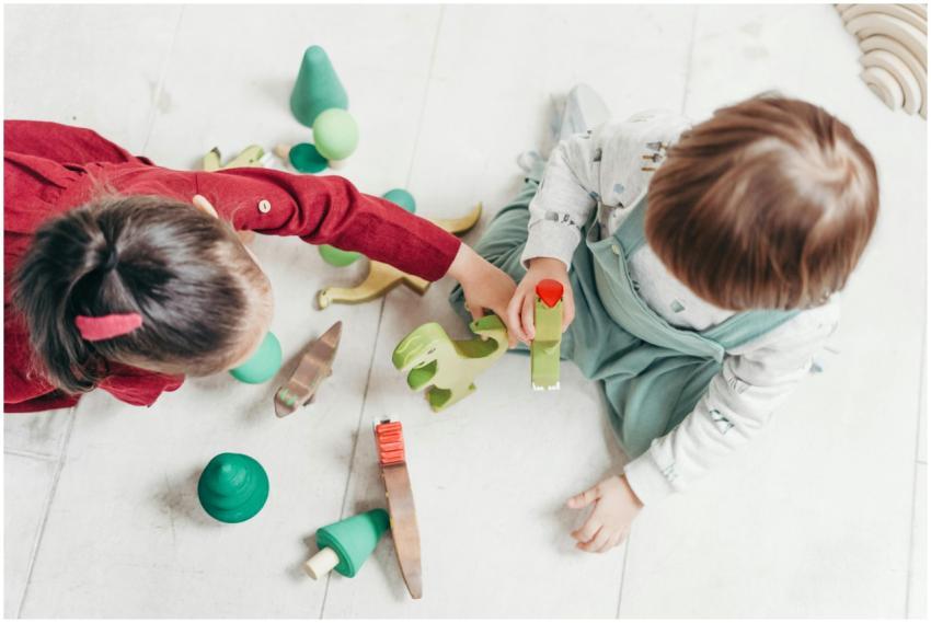 Two young children playing with colorful wooden to